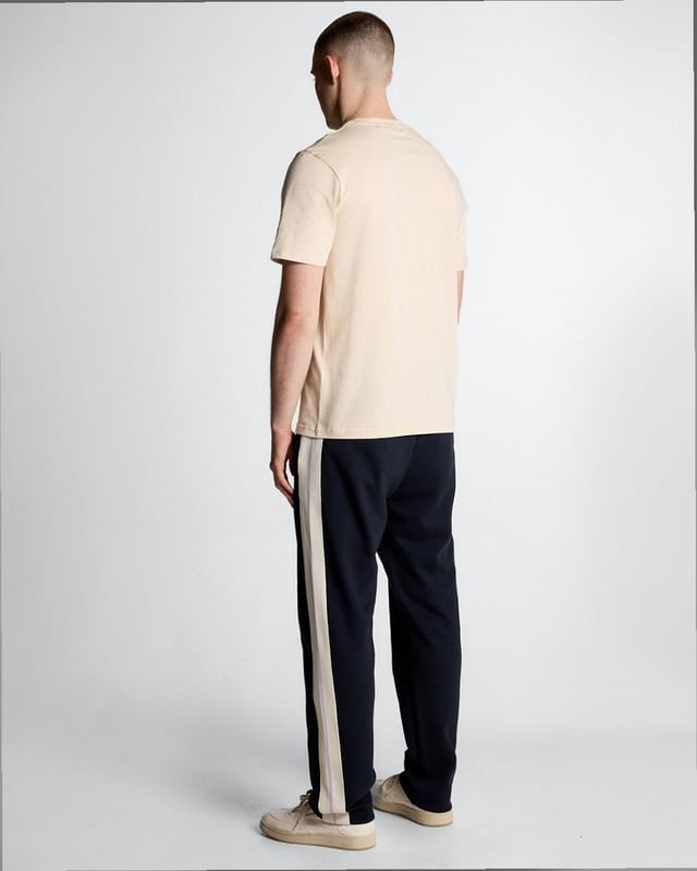 Entdecken Sie den Inbegriff gehobener Freizeitkleidung mit unseren Taped Track Joggers aus der Legacy-Kollektion. Diese Jogginghose wurde für den anspruchsvollen Gentleman gefertigt und vereint eleganten Stil mit unvergleichlichem Komfort – ein unverzichtbares Accessoire für Ihre Garderobe. - Zusammensetzung: 55 % Baumwolle, 45 % Polyester für Atmungsaktivität und Strapazierfähigkeit - Passform: Normal geschnitten für eine elegante Silhouette - Logo-Branding: Dezent und doch markant - Branding-Position: Strategisch platziert für einen modernen Look - Vielseitiges Styling: Perfekt für legere Ausflüge oder entspannte Wochenenden Gönnen Sie sich die perfekte Kombination aus Luxus und Funktionalität – die Essenz eleganter Frühlingsmode für Herren.