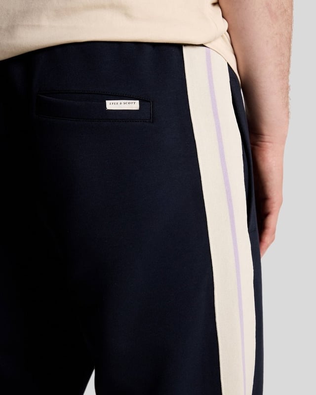 Entdecken Sie den Inbegriff gehobener Freizeitkleidung mit unseren Taped Track Joggers aus der Legacy-Kollektion. Diese Jogginghose wurde für den anspruchsvollen Gentleman gefertigt und vereint eleganten Stil mit unvergleichlichem Komfort – ein unverzichtbares Accessoire für Ihre Garderobe. - Zusammensetzung: 55 % Baumwolle, 45 % Polyester für Atmungsaktivität und Strapazierfähigkeit - Passform: Normal geschnitten für eine elegante Silhouette - Logo-Branding: Dezent und doch markant - Branding-Position: Strategisch platziert für einen modernen Look - Vielseitiges Styling: Perfekt für legere Ausflüge oder entspannte Wochenenden Gönnen Sie sich die perfekte Kombination aus Luxus und Funktionalität – die Essenz eleganter Frühlingsmode für Herren.