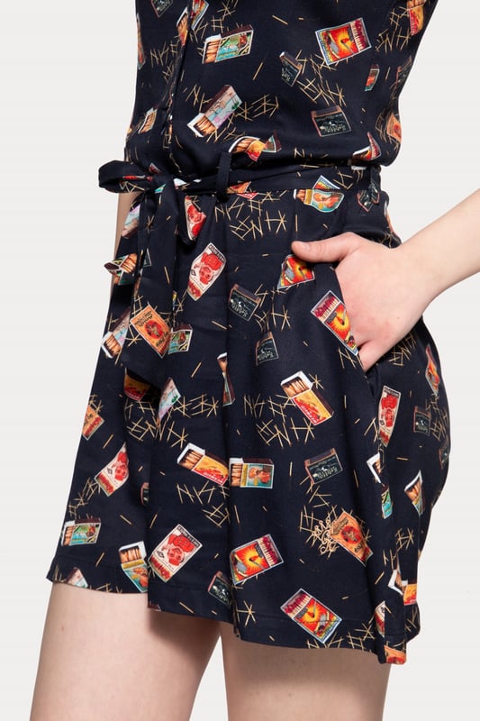 Du hast keine Lust ein Kleid zu tragen, möchtest aber trotzdem den sommerlichen Vintage Look? Dann ist der Jumpsuit aus Viskose von Queen Kerosin genau das Richtige für dich! Das verwendete Material besteht aus reiner Viskose, was sich leicht und weich auf der Haut anfühlt und sich zusammen mit dem bequemen Regular Fit bestens für den Sommer eignet. Der ärmellose Jumpsuit besitzt formgebende Wiener Nähte, einen Reverskragen, eine Knopfleiste in der Front und einen Bindegürtel in der Taille. Highlight des Ganzen ist jedoch das coole All-Over Matchbox Muster. Für einen angenehmes, unkompliziertes An- und Ausziehen befindet sich ein nahtverdeckter Reißverschluss in der Seitennaht. Ein echter Allrounder, der in keiner Garderobe eines Vintage-Fans fehlen sollte!  QUEEN KEROSIN: Queen Kerosin steht für den amerikanischen Zeitgeist der 50er Jahre mit Rock'n'Roll Rockabilly, Motorrädern, Bikes, Hot Rod und allem was dazu gehört! Unsere Design mit Vintage Charme bringen Dich zurück in die gute ZeitDESIGN: Ein komplettes Outfit in einem; mit dem Queen Kerosin Damen Jumpsuit mit coolem Vintage All-Over Muster. Der ärmellose Overall hat einen Reverskragen, eine Knopfleiste und einen Bindegürtel in der TaillePASSFORM: Im Gegenzug zu den weit geschnittenen Beinen, liegt der Jumpsuit im Regular Fit durch seine formgebenden Wiener Nähte oben gut an. Ein Bindegürtel in der Taille sorgt zusätzlich für einen angenehmen Sitz MATERIAL: Das Material besteht aus reiner Viskose und fühlt sich leicht und weich auf der Haut an, was für einen excellenten Tragekomfort spricht  KOMBINATIONSMÖGLICHKEITEN: Super Allrounder für den Sommer!LIEFERUMFANG: Der feminine Damen Sommer Jumpsuit ist in den Größen XS S M L XL XXL 3XL und 4XL erhältlich