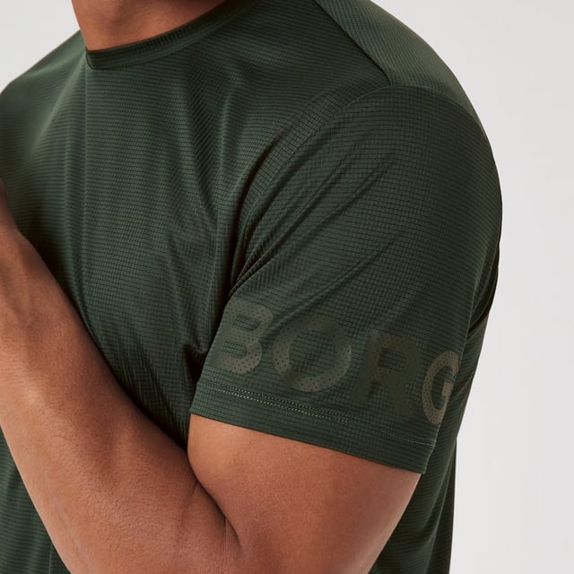 Borg Light T-shirt - Sustainable Performance Wear: Elevate your active wardrobe with the Björn Borg Borg Light T-shirt, designed for those who demand both style and sustainability. Crafted from 100% recycled polyester, this performance tee offers a regular fit and features a longer length, making it ideal for high-intensity workouts, especially those involving overhead movements. The T-shirt is quick-drying and includes iconic Borg branding on the sleeves, combining function and fashion effortlessly. Perfect for year-round use, this versatile T-shirt is available in a range of seasonal colors. Extra Product Details:. 100% Recycled Polyester Regular Fit with Longer length Quick-Drying Fabric Borg Print on Arms Round Neckline Machine Washable Ideal for All Seasons. This T-shirt is an essential addition to any fitness enthusiast's wardrobe, delivering performance while contributing to a more sustainable planet.