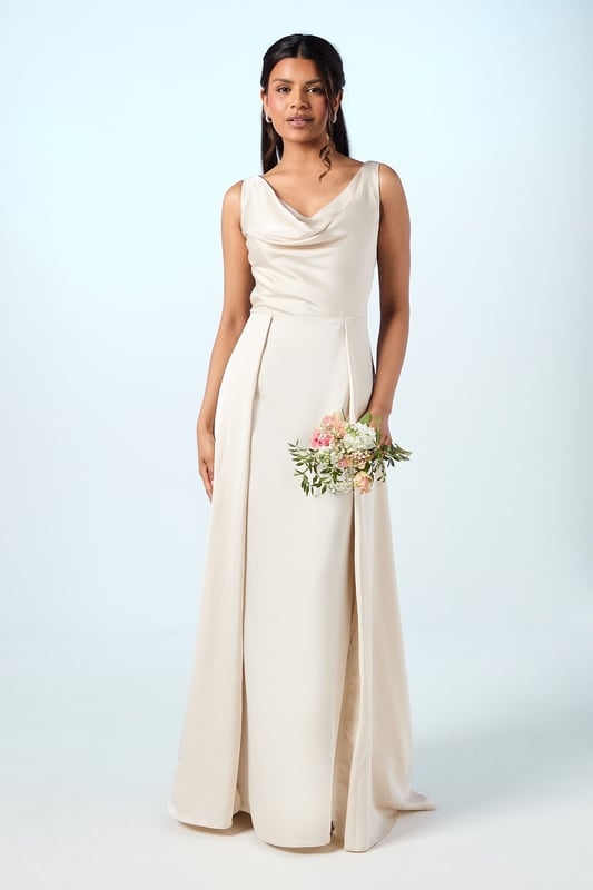 Elegant sleeveless maxi dress with a graceful cowl neckline that drapes beautifully
        Luxurious satin fabric that catches the light with subtle sheen
        Petite-friendly design with proportions tailored for shorter frames
        Flattering pleated detail that creates a flowing silhouette
        Floor-length design with a clean, sophisticated line perfect for formal occasions
    
    The Honoured Petite Bridesmaid Dress from Coast embodies timeless elegance with its fluid satin construction and graceful cowl neckline. Designed specifically for petite frames, this maxi dress offers both comfort and sophistication for your special role in the bridal party. The sleeveless cut allows for ease of movement throughout the celebration, while the pleated detailing creates a flattering shape that moves beautifully as you walk down the aisle. Complete your bridesmaid ensemble with delicate drop earrings and a simple bracelet as shown on our model, keeping accessories minimal to complement the dress's refined aesthetic. For a coordinated bridal party look, this style can be harmonised with other Coast bridesmaid dresses in matching tones, creating a cohesive and memorable wedding day aesthetic that will photograph beautifully alongside the bride.