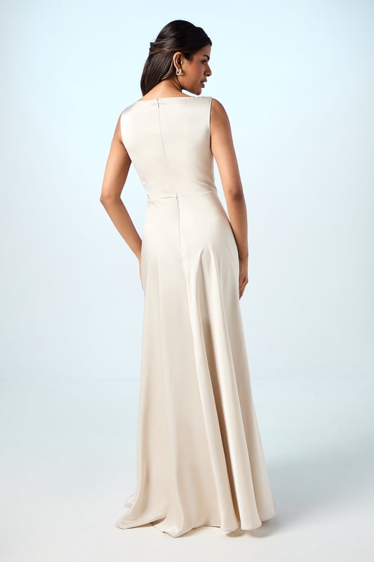Elegant sleeveless maxi dress with a graceful cowl neckline that drapes beautifully
        Luxurious satin fabric that catches the light with subtle sheen
        Petite-friendly design with proportions tailored for shorter frames
        Flattering pleated detail that creates a flowing silhouette
        Floor-length design with a clean, sophisticated line perfect for formal occasions
    
    The Honoured Petite Bridesmaid Dress from Coast embodies timeless elegance with its fluid satin construction and graceful cowl neckline. Designed specifically for petite frames, this maxi dress offers both comfort and sophistication for your special role in the bridal party. The sleeveless cut allows for ease of movement throughout the celebration, while the pleated detailing creates a flattering shape that moves beautifully as you walk down the aisle. Complete your bridesmaid ensemble with delicate drop earrings and a simple bracelet as shown on our model, keeping accessories minimal to complement the dress's refined aesthetic. For a coordinated bridal party look, this style can be harmonised with other Coast bridesmaid dresses in matching tones, creating a cohesive and memorable wedding day aesthetic that will photograph beautifully alongside the bride.