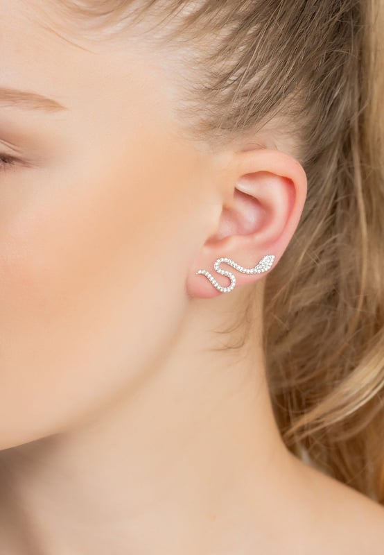 Add a little drama to your look with the Nagini Snake Ear Climbers! We know that jewellery can transform your look, and this ear climber will do just that. Not only is it light as a feather at 3.6 grams so you won't even feel it, it's handcrafted with 925 sterling silver and set with sparkling zirconia for subtle shimmer and a stunning appeal. It easily secures against your earlobe with the hook fastening, which creates an illusion of having two snakes crawling up the edges of your ears!Jewellery featuring snakes has long been a popular choice. In ancient Greek mythology, for example, the snake was associated with wisdom and healing. In Hinduism, it's an important symbol of fertility and creation. Today, snakes can be seen as a representation of transformation, rebirth, and regeneration. They can serve as an empowering symbol of strength and courage.Plus, at 3cm in length and 1.3cm in width, this is sure to make a statement without looking too over-the-top. So if you're daring enough, go ahead and try out this sssshimmery snake ear climber!