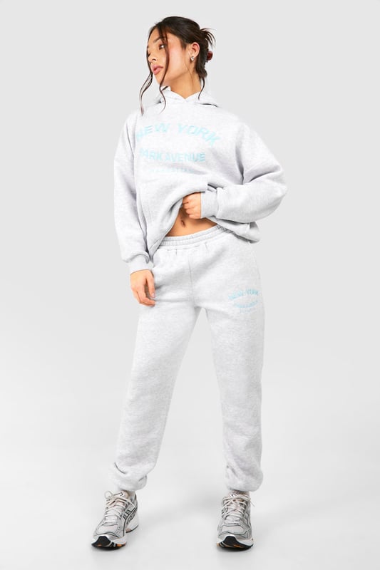 Cosy tracksuit with New York embroidery
        Relaxed fit hoodie with ribbed cuffs and hem
        Matching joggers with tapered leg
        Soft cotton-feel fabric for ultimate comfort
        Versatile two-piece set for effortless styling
    
    Embrace laid-back chic with this petite tracksuit, perfect for those who want to make a statement whilst staying comfortable. The New York embroidery adds a touch of urban flair, making it ideal for city dwellers and travellers alike. Style this set with chunky trainers for a casual day out, or dress it up with statement jewellery and heeled boots for an evening with friends. The versatility of this tracksuit means it can take you from lounging at home to running errands in town with ease. For a sporty look, pair with a baseball cap and crossbody bag. This tracksuit is a must-have for your casual wardrobe, offering both style and comfort for various informal occasions.