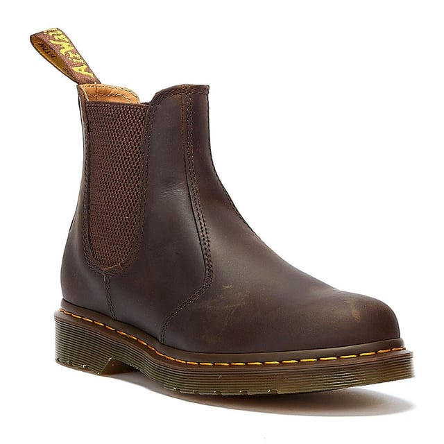 Der 2976 ist der zeitlose Chelsea-Stiefel von DM, der erstmals in den 70er Jahren produziert wurde und seither für seine sichere Passform, das einfache An- und Ausziehen sowie seinen mühelosen Stil verehrt wird. Diese Version zeichnet sich durch die ikonische gelbe Naht am Obermaterial aus und besteht aus strapazierfähigem Crazy Horse-Leder, das einen robusten, aber eleganten Stil bietet.