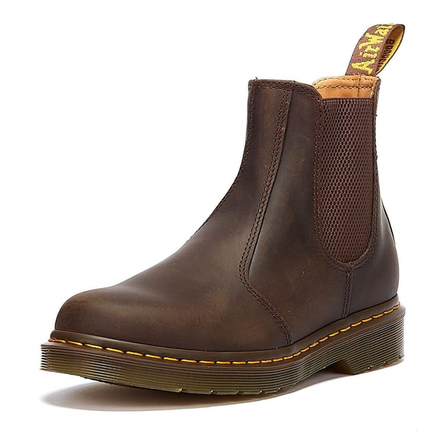 Der 2976 ist der zeitlose Chelsea-Stiefel von DM, der erstmals in den 70er Jahren produziert wurde und seither für seine sichere Passform, das einfache An- und Ausziehen sowie seinen mühelosen Stil verehrt wird. Diese Version zeichnet sich durch die ikonische gelbe Naht am Obermaterial aus und besteht aus strapazierfähigem Crazy Horse-Leder, das einen robusten, aber eleganten Stil bietet.