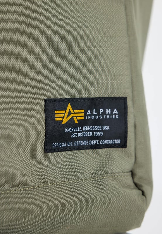 Alpha Backpack Tote Bag La Alpha Backpack Tote Bag combina funcionalidad y estilo. Su resistente exterior de poliéster es ligero y fácil de cuidar, ideal para el trabajo, la universidad o el tiempo libre. Ofrece un amplio espacio para el portátil y mucho más. Las asas de mano tejidas y las correas de hombro ajustables permiten llevarla como bolso o como mochila. Su diseño discreto combina con cualquier conjunto, y su construcción robusta garantiza durabilidad. Práctica, moderna y elegante: el estilo Alpha Industries en estado puro.