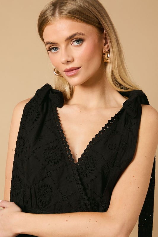 Intricate broderie anglaise detailing throughout for a feminine touch
        Flattering V-neckline at front and back for an elegant silhouette
        Charming tie shoulder straps that add a playful detail
        Tiered midi-length skirt with a relaxed, flowing shape
        Defined waistband that creates a beautifully structured fit
    
    This delightful broderie midi dress from Oasis captures effortless summer style with its feminine details and comfortable fit. The tie shoulders allow for a customised fit whilst adding a whimsical touch to the overall design. Perfect for daytime occasions, style with flat sandals as shown for a relaxed garden party or family lunch. For cooler days, layer with a lightweight denim jacket and trainers for a casual weekend look. The versatile design transitions beautifully from a countryside walk to an afternoon tea with friends. Accessorise with simple gold jewellery and a woven bag to complement the dress's intricate texture. The midi length offers both comfort and sophistication, making this a wardrobe staple that will see you through numerous casual events with ease and grace.