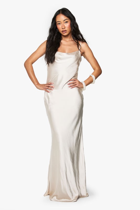 Elegant satin maxi dress with a stunning cowl neckline that drapes beautifully
        Figure-flattering silhouette with a sleek, floor-length design
        Adjustable spaghetti straps for a customised fit
        Dramatic cowl back detail adds a touch of sophistication
        Smooth, flowing fabric that glides gracefully with movement
    
    Make a striking impression at your next formal occasion with this Boohoo bridesmaid satin maxi dress. The luxurious fabric catches the light beautifully as you move, whilst the cowl neckline frames your dcolletage with effortless elegance. Style with delicate jewellery and a small clutch bag, as shown on our model, to maintain the dress's refined silhouette. Perfect for weddings, formal dinners, and black-tie events, this gown offers timeless appeal that photographs beautifully. The draped back detail adds unexpected drama when you turn, ensuring you look just as captivating from every angle. For cooler evenings, pair with a lightweight pashmina or tailored jacket to complete your sophisticated ensemble.