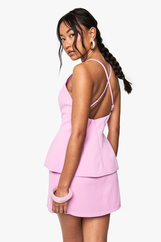 Striking plunge neckline for a bold, feminine silhouette
        Elegant peplum design creating a flattering two-piece effect
        Cross-back strappy detail adding visual interest from every angle
        Sleek crepe fabric offering a structured yet comfortable fit
        Mini length perfect for showcasing your legs and favourite heels
    
    Make a statement at your next special occasion with this sophisticated mini dress from Boohoo. The contemporary peplum silhouette creates a figure-enhancing shape whilst the deep V-neckline adds a touch of allure. The cross-back strappy detail ensures you'll turn heads coming and going. Style with strappy heeled sandals and a compact clutch bag as shown for formal events such as cocktail parties or race day outings. For cooler evenings, layer with a tailored blazer or delicate wrap. Complete your look with statement earrings and a sleek updo to showcase the beautiful neckline and back detail. This versatile piece transitions effortlessly from graduation ceremonies to wedding receptions with just a change of accessories.