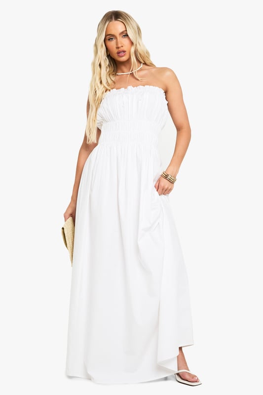 Elegant bandeau neckline with delicate ruched detailing across the bodice
        Lightweight cotton poplin fabric offers breathable comfort for all-day wear
        Floor-sweeping maxi length creates a graceful silhouette
        Elasticated shirred upper section ensures a comfortable, secure fit
        Flowing skirt design provides effortless movement and versatility
    
    This stunning cotton maxi dress showcases beautiful ruched detailing that creates a flattering silhouette whilst maintaining day-long comfort. The strapless bandeau design presents the perfect canvas for showcasing your favourite jewellery, as demonstrated by the model's choice of layered necklaces. Style with flat sandals and a woven clutch for casual garden parties or family gatherings. For a more refined daytime look, add a cropped denim jacket and delicate bangles. The dress's relaxed fit makes it ideal for warm-weather holidays - simply throw on with oversized sunglasses and a wide-brimmed hat for instant beachside sophistication. The versatile design transitions seamlessly from day to evening, making it a must-have addition to your summer wardrobe.