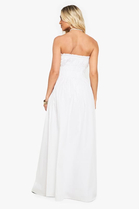 Elegant bandeau neckline with delicate ruched detailing across the bodice
        Lightweight cotton poplin fabric offers breathable comfort for all-day wear
        Floor-sweeping maxi length creates a graceful silhouette
        Elasticated shirred upper section ensures a comfortable, secure fit
        Flowing skirt design provides effortless movement and versatility
    
    This stunning cotton maxi dress showcases beautiful ruched detailing that creates a flattering silhouette whilst maintaining day-long comfort. The strapless bandeau design presents the perfect canvas for showcasing your favourite jewellery, as demonstrated by the model's choice of layered necklaces. Style with flat sandals and a woven clutch for casual garden parties or family gatherings. For a more refined daytime look, add a cropped denim jacket and delicate bangles. The dress's relaxed fit makes it ideal for warm-weather holidays - simply throw on with oversized sunglasses and a wide-brimmed hat for instant beachside sophistication. The versatile design transitions seamlessly from day to evening, making it a must-have addition to your summer wardrobe.