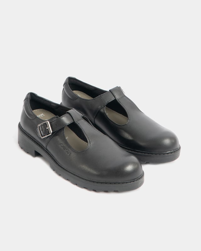 These girls' school shoes feature a leather upper, fabric lining, synthetic sole, and a buckle closure. They offer a comfortable fit with a round toe and low-top design for everyday wear