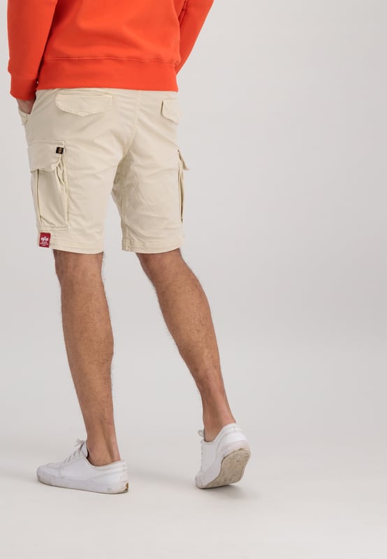 The Airman Short is a versatile and stylish garment. It is crafted from a cotton twill blend with a touch of elastane for stretch, featuring a slim fit and cargo pockets for a practical touch. The small Alpha Industries logo on the side pocket adds a subtle branding detail.
