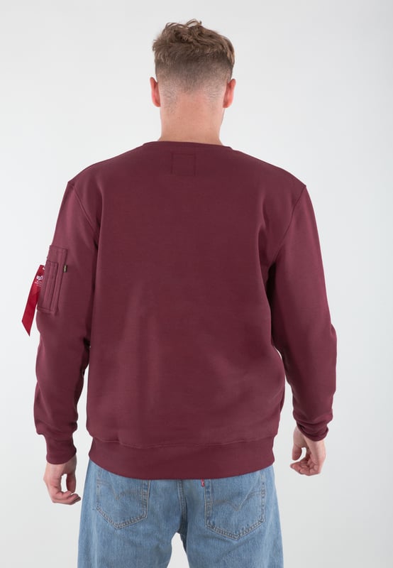 The jumper is made from a soft knitted fabric with cuffs that keep it in place. It also features a reflective Alpha Industries logo on the chest.