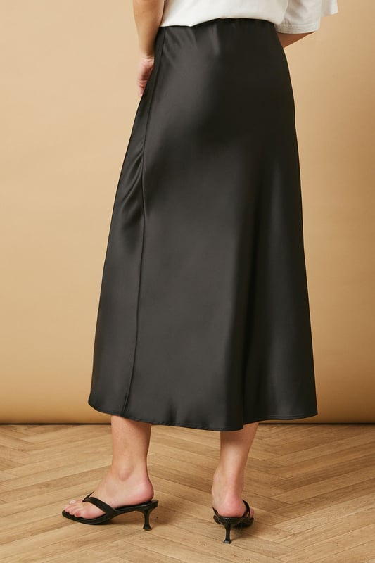 Elegant bias cut design creates a flattering drape that skims the silhouette
        Lustrous satin finish catches the light beautifully as you move
        Mid-calf length offers versatile styling options for various occasions
        Smooth waistband sits comfortably at the natural waist
        Fluid A-line shape provides effortless movement throughout the day
    
    This Oasis bias cut midi skirt brings timeless sophistication to your everyday wardrobe. The diagonal cutting technique creates a gorgeous drape that flows with your body, whilst the satin finish adds a subtle touch of luxury to casual ensembles. Style as seen with a relaxed oversized tee and minimal flip-flop sandals for an effortlessly chic daytime look. For family gatherings or brunches with friends, pair with a fitted knit top and ballet flats. The versatile midi length works beautifully with trainers for a contemporary twist, or dress it up with block-heeled mules for dinner dates. This skirt transitions seamlessly from weekend shopping trips to casual office settings when paired with a crisp button-down and loafers. A true wardrobe essential that combines feminine charm with practical wearability.