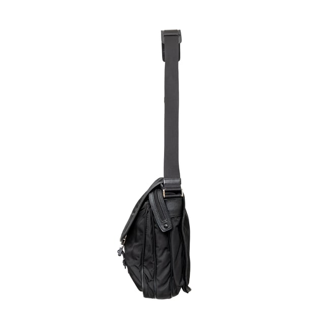 VINTAGE, RRP AS NEW
This black re-nylon messenger bag with trim features dual buckle closures on pockets, a side lock, and an enamel triangle signature brand emblem for a sleek finish.
Inclusion: dust bag
Remarks: there are some signs of wear on the hardware. Measurments:  width: 965 mm height: 812 mm
