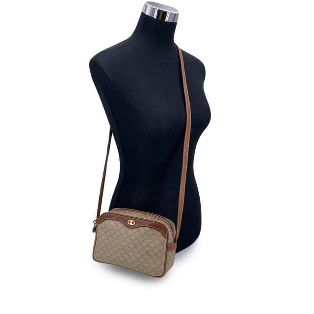 VINTAGE, RRP AS NEW
Embrace classic elegance with this beautiful vintage Celine small Macadam crossbody bag-a timeless piece that captures the charm of 1990s-era luxury. Expertly crafted from Celine's signature beige Macadam vinyl canvas and accented with light brown genuine leather trim, this compact silhouette is both chic and practical.  The bag features gold metal hardware that adds a touch of shine, while the adjustable leather shoulder strap ensures comfortable crossbody wear. An upper zipper closure opens to reveal a clean leather-lined interior, complete with a side zip pocket for your essentials.  Inside, the "Celine Paris" tag and Made in Italy stamp attest to its craftsmanship. Whether you're strolling through the city or dressing up your everyday look, this vintage Celine crossbody brings understated sophistication to every outfit Condition Rating: B - VERY GOOD CONDITIONCondition Details: Gently used. Some wear of use (scratches) leather trim and shoulder strap (especially on bottom corners). Some scratches on the internal lining. Please check the photos carefully and ask if you need to know more details or if you have any doubts.Measurements (cm):Depth: 7.6Height: 12.7Length: 19.1Other Details: Dustbag? NoKeys? NoBox? No Measurments:  width: 76 mm length: 191 mm height: 127 mm