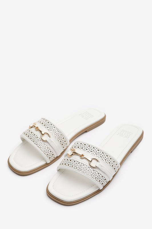 Wheres That From Womens 'Natalie' Sliders With Geometric Strap And Metal Detail Step into timeless elegance with these Natalie Sliders With Geometric Strap And Metal Detail. Designed with a chic metallic horse-bit buckle, they effortlessly blend sophistication and comfort. The perforated upper adds breathable style, while the slip-on design makes them ideal for effortless wear from day to night. Perfect for holidays, casual brunches, or a polished everyday look. Key Features: • Material: Faux leather upper with a cushioned insole for all-day comfort • Design: Perforated detailing with a stylish horse-bit buckle accent • Closure: Easy slip-on style for convenience