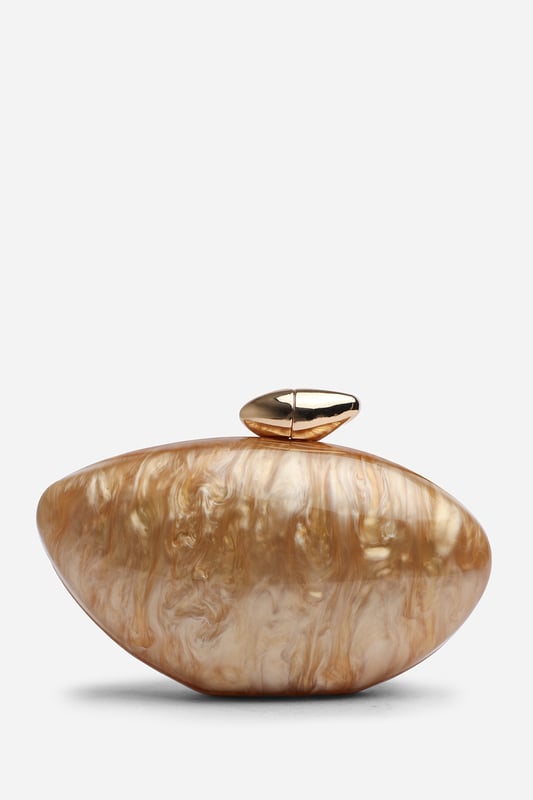 Make a statement with the ocean-inspired Benna Marble Acrylic Clutch In Gold, designed to turn heads at any special event. Its sculpted silhouette and glossy marbled finish evoke luxurious, artistic charm. Finished with a sleek gold-tone clasp, this compact clutch carries your essentials in standout style. Key Features: • Material: High-gloss marbled acrylic • Dimensions: Approximately 19cm (L) x 11cm (H) x 5cm (W) • Fastening: Gold-tone twist clasp closure • Detail: Unique curved design with swirling marble effect for a luxe finish