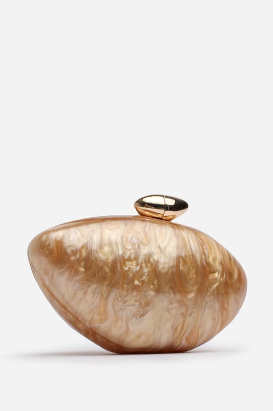 Make a statement with the ocean-inspired Benna Marble Acrylic Clutch In Gold, designed to turn heads at any special event. Its sculpted silhouette and glossy marbled finish evoke luxurious, artistic charm. Finished with a sleek gold-tone clasp, this compact clutch carries your essentials in standout style. Key Features: • Material: High-gloss marbled acrylic • Dimensions: Approximately 19cm (L) x 11cm (H) x 5cm (W) • Fastening: Gold-tone twist clasp closure • Detail: Unique curved design with swirling marble effect for a luxe finish