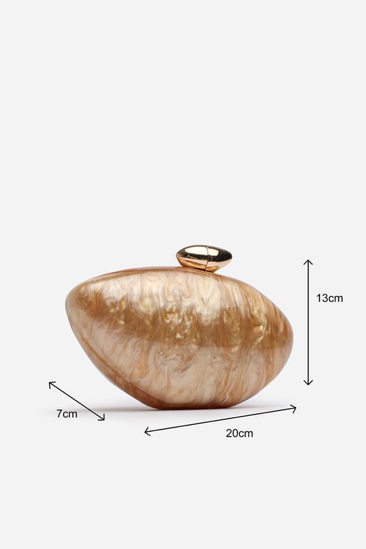 Make a statement with the ocean-inspired Benna Marble Acrylic Clutch In Gold, designed to turn heads at any special event. Its sculpted silhouette and glossy marbled finish evoke luxurious, artistic charm. Finished with a sleek gold-tone clasp, this compact clutch carries your essentials in standout style. Key Features: • Material: High-gloss marbled acrylic • Dimensions: Approximately 19cm (L) x 11cm (H) x 5cm (W) • Fastening: Gold-tone twist clasp closure • Detail: Unique curved design with swirling marble effect for a luxe finish