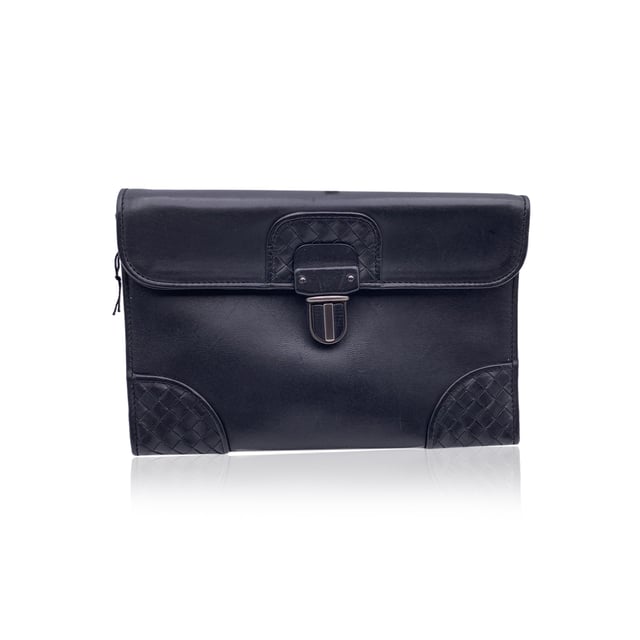 VINTAGE, RRP AS NEW
Understated elegance meets artisanal mastery in this vintage Bottega Veneta black leather wrist bag. Crafted in supple leather, this sleek piece is elevated by the brand's signature Intrecciato weave, subtly framing the corners and flap closure - a quiet nod to Bottega's heritage of handwoven luxury.  The structured flap front secures with a classic lock closure, opening to reveal a minimalist black fabric-lined interior, just enough for your essentials. A leather wrist strap adds both function and flair, making it the perfect companion for evenings out or a refined daytime statement.  Inside, the engraved 'Bottega Veneta - Made in Italy' inscription confirms what the craftsmanship already suggests: this is quiet luxury at its finest, designed to be worn, admired, and passed on. Condition Rating: B - VERY GOOD CONDITIONCondition Details: Some light scratches on leather due to normal use. Please check the photos carefully and ask if you need to know more details or if you have any doubts.Measurements (cm):Depth: 5.1Height: 16.5Length: 24.1Other Details: Dustbag? YesKeys? NoBox? No Measurments:  width: 51 mm length: 241 mm height: 165 mm
