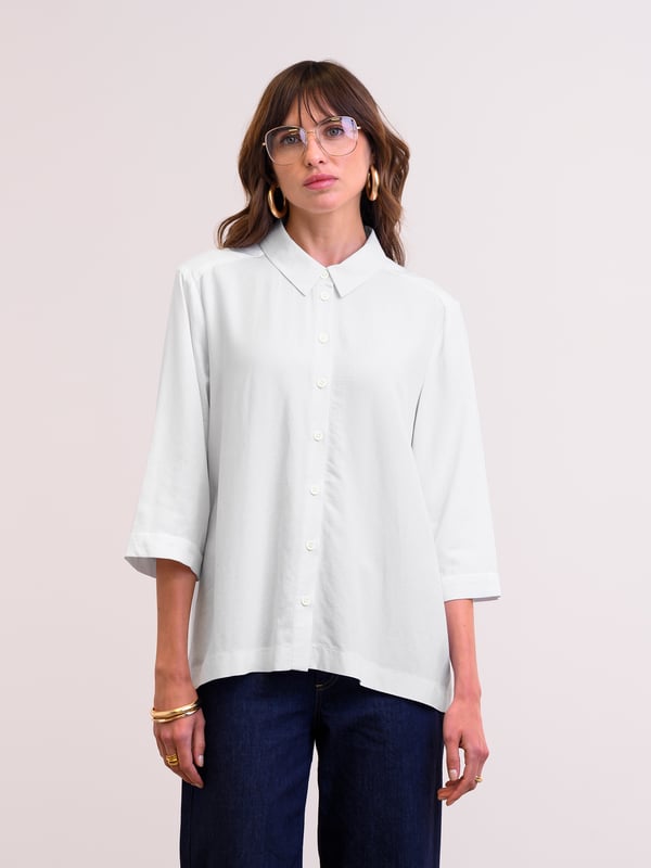 This flattering shirt features a slightly swing shape due to the deep box pleat detail at the back. With a curved hem, which is slightly longer at the back for more coverage, and cropped three-quarter-length sleeves with wide cuffs, the silhouette is clean and modern. The shirt collar, full-length button-through placket, and buttons made from Corozo nut complete the shirt.