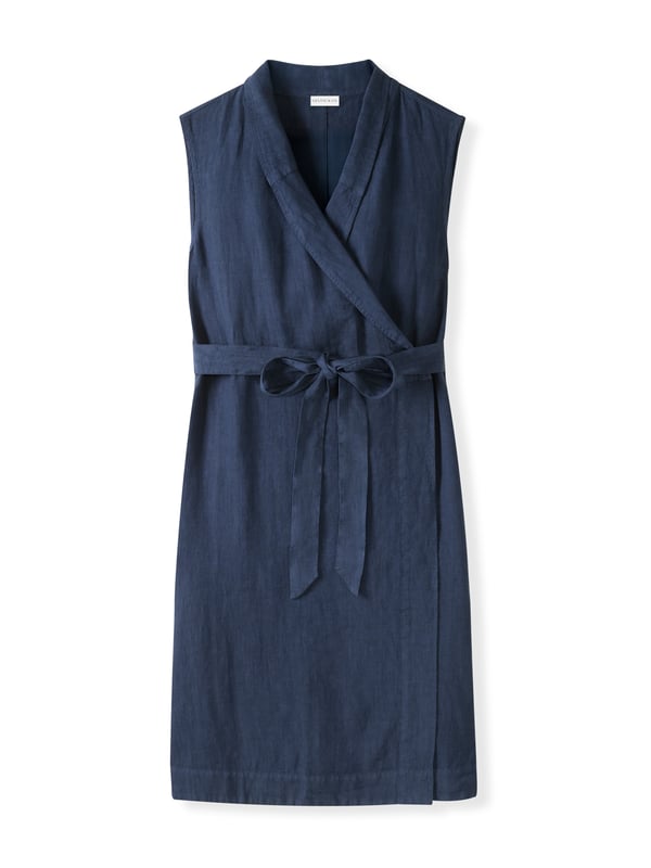 This wrap dress features a shawl collar neckline with adjustable self-ties at the back for a custom fit. Knee-length and sleeveless with practical side-seam pockets, it combines easy style with versatility.