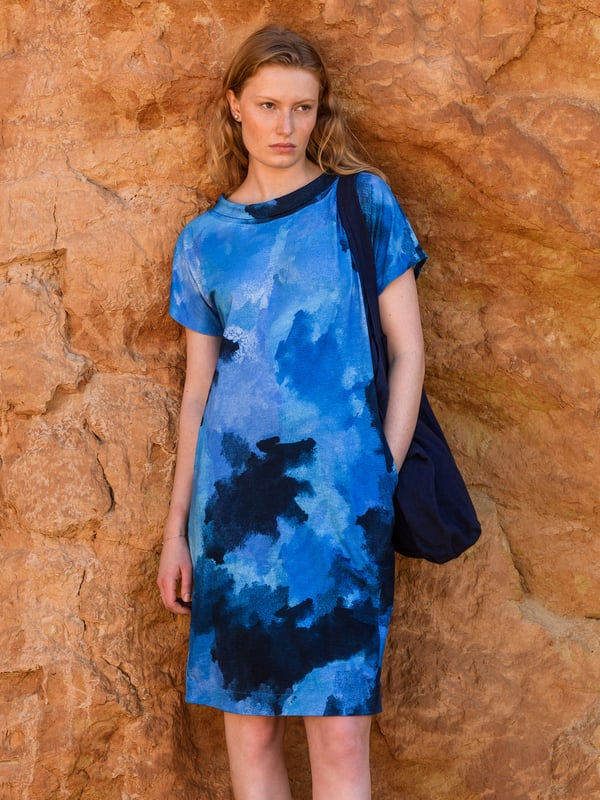 This knee-length dress offers a relaxed, straight fit with a folded boat collar and grown-on sleeves. The slub jersey fabric adds subtle texture, while practical side seam pockets provide versatility for everyday wear.