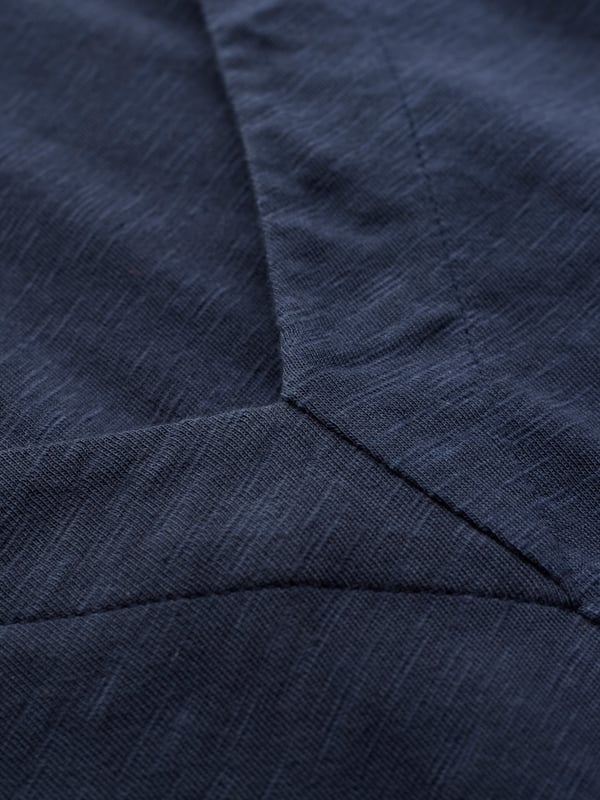 A sleeveless midi with a soft V neckline, this dress has a side seam pocket detail and a back hem split for added movement. The slub texture lends a casual touch, ideal for warm weather layering or simple styling.