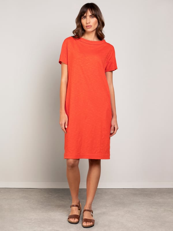 This knee-length dress offers a relaxed, straight fit with a folded boat collar and grown-on sleeves. The slub jersey fabric adds subtle texture, while practical side seam pockets provide versatility for everyday wear.