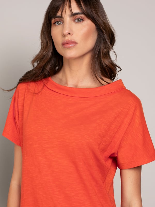 This knee-length dress offers a relaxed, straight fit with a folded boat collar and grown-on sleeves. The slub jersey fabric adds subtle texture, while practical side seam pockets provide versatility for everyday wear.