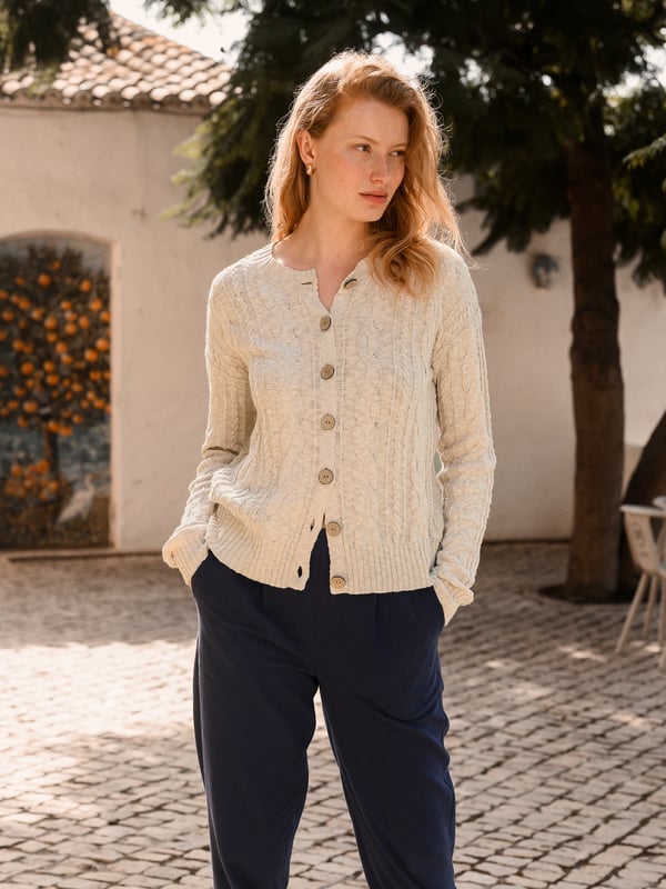 This cardigan has a classic cable-knit pattern with a relaxed, drop-shoulder shape, finished with natural coconut buttons. The cotton-linen blend lends an airy feel, while the crew neckline and boxy fit create an easy, everyday layer.
