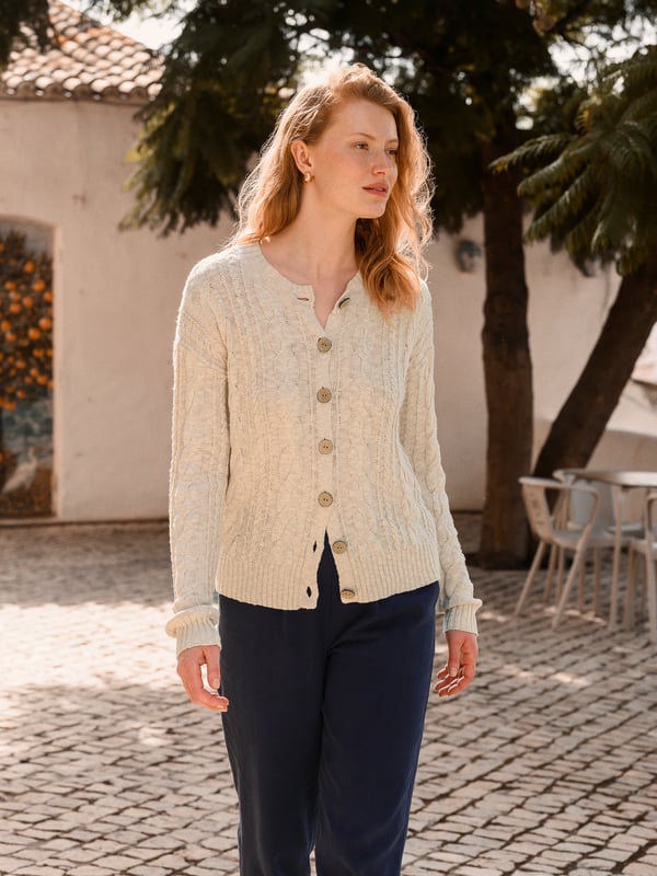 This cardigan has a classic cable-knit pattern with a relaxed, drop-shoulder shape, finished with natural coconut buttons. The cotton-linen blend lends an airy feel, while the crew neckline and boxy fit create an easy, everyday layer.