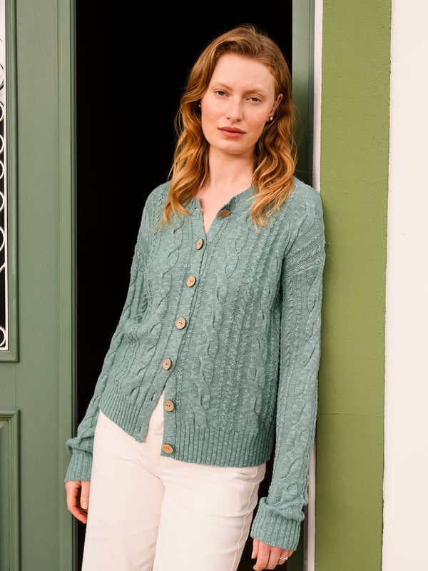 This cardigan has a classic cable-knit pattern with a relaxed, drop-shoulder shape, finished with natural coconut buttons. The cotton-linen blend lends an airy feel, while the crew neckline and boxy fit create an easy, everyday layer.