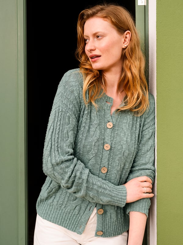This cardigan has a classic cable-knit pattern with a relaxed, drop-shoulder shape, finished with natural coconut buttons. The cotton-linen blend lends an airy feel, while the crew neckline and boxy fit create an easy, everyday layer.