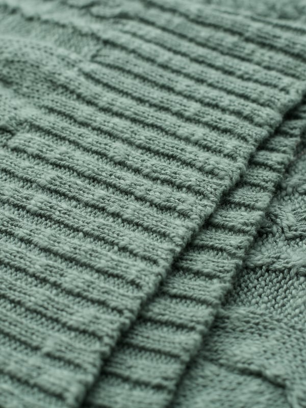 This cardigan has a classic cable-knit pattern with a relaxed, drop-shoulder shape, finished with natural coconut buttons. The cotton-linen blend lends an airy feel, while the crew neckline and boxy fit create an easy, everyday layer.