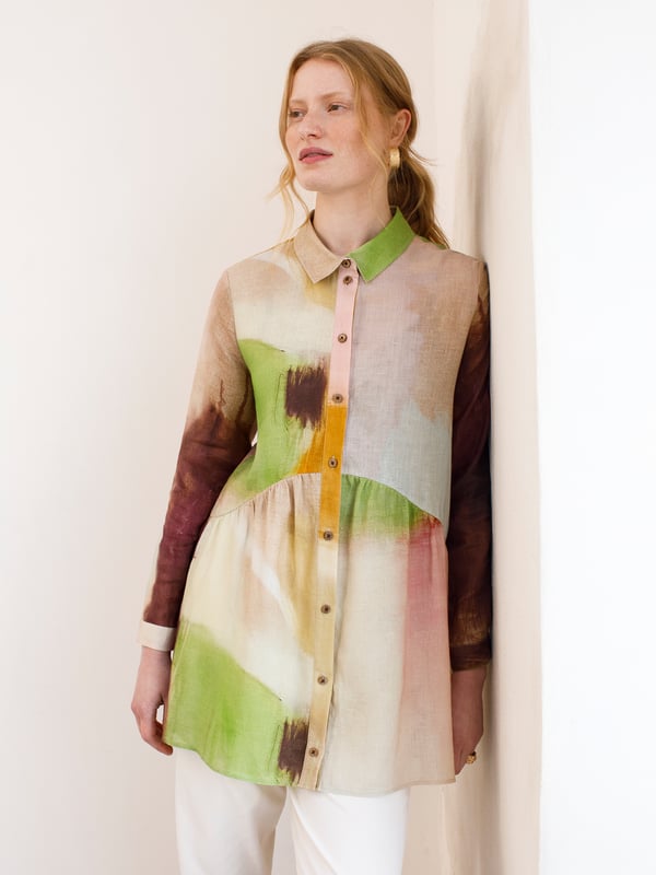 Linen Gathered Waist Tunic This tunic-length shirt is made from garment-dyed and washed linen, offering a softer, tumbled look. The fit is more oversized, with a curved seam running from the front to the back, creating a fuller gathered peplum around the lower part of the garment. The shirt collar, full-length button-through placket, and full-length shirt sleeves with buttons made from Corozo nut complete the design.