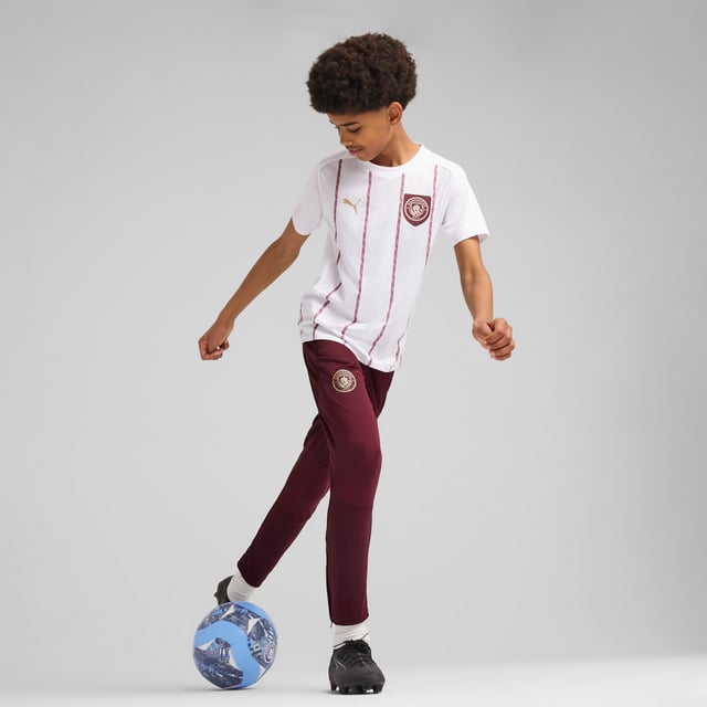 PUMA Kids Unisex Manchester City Pre-match Jersey PRODUCT STORY: Show your love for Manchester's best club with this PUMA jersey. Featuring iconic team branding, high-performance details, and sleek PUMA details, it's perfect for cheering at the Etihad Stadium or repping your team wherever you go. Feel the energy, wear the pride. FEATURES & BENEFITS: dryCELL: Performance technology designed to wick moisture from the body and keep you free of sweat during exercise; Made with 100% recycled material excluding trims & decorations. DETAILS: Regular fit; Single jersey material; Regular length; Crew neck; Short sleeves; Medium rise; Printed graphic; Manchester City badge and PUMA Cat logo; PUMA Youth: Recommended for older kids between 8 and 16 years.