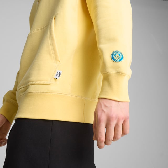 PRODUCT STORY: Show your love for the Cityzens with this MMQ hoodie. Featuring a PUMA Cat embroidery, adjustable hood, and premium French terry fabric, it's all about minimalistic aesthetics and sophisticated details. Celebrate your club with the finest quality and contemporary design that speaks volumes at the Etihad Stadium and beyond. FEATURES & BENEFITS: Made with at least 20% recycled cotton. DETAILS: Relaxed fit; Terry material; Regular length; Hood; Long sleeves; Kangaroo pocket; PUMA branding details.