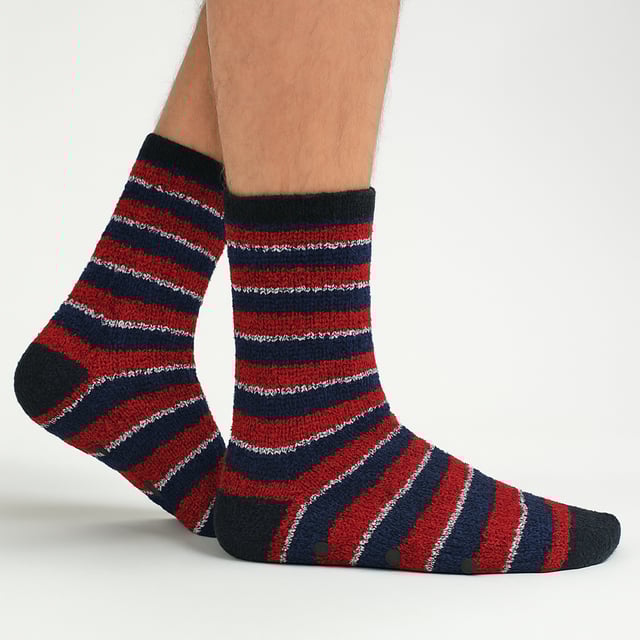 Calcetines acogedores gruesos para hombres Sock Snob (paquete de 4): Los calcetines acogedores gruesos para hombres de Sock Snob son la elección perfecta para aquellos que necesitan un poco de calor y comodidad extra en su vida. Estos lujosos calcetines para cama, suaves, gruesos y esponjosos, mantendrán tus pies cómodos en casa, sin importar cuán frío esté afuera. Ideales para mantener tus pies calientes durante los meses de invierno, estos suaves y esponjosos calcetines tienen antideslizantes en la suela para prevenir resbalones y caídas en superficies de madera dura, proporcionando un agarre adicional. Gruesos y súper cálidos, estos calcetines son perfectos para el clima frío. Han sido diseñados con un tejido más grueso para garantizar que sean duraderos y resistan un uso repetido. Póntelos después de un largo día y pasa una velada relajándote en casa. Estos calcetines vienen en 3 combinaciones de colores diferentes, así que puedes elegir el par perfecto para ti: Gris/Azul, Negro/Rayas Naranjas y Azul/Rayas Rojas. También serían un excelente regalo para el hombre en tu vida, dándole comodidad y calor adicionales. Estos calcetines para hombres vienen en 4 pares por paquete y están disponibles en 3 opciones de color. Están hechos de: 98% Poliéster y 2% Elastano, son de talla única para hombres: 6-11 UK (39-45 EUR, 7-12 US) y son completamente lavables a máquina. Detalles adicionales del producto: Calcetines acogedores para hombres 4 pares por paquete Calcetines de cama esponjosos Antideslizantes Gruesos y cálidos Hechos para el invierno Perfectos para relajarse en casa 3 opciones de color Talla única para hombres: 6-11 UK
