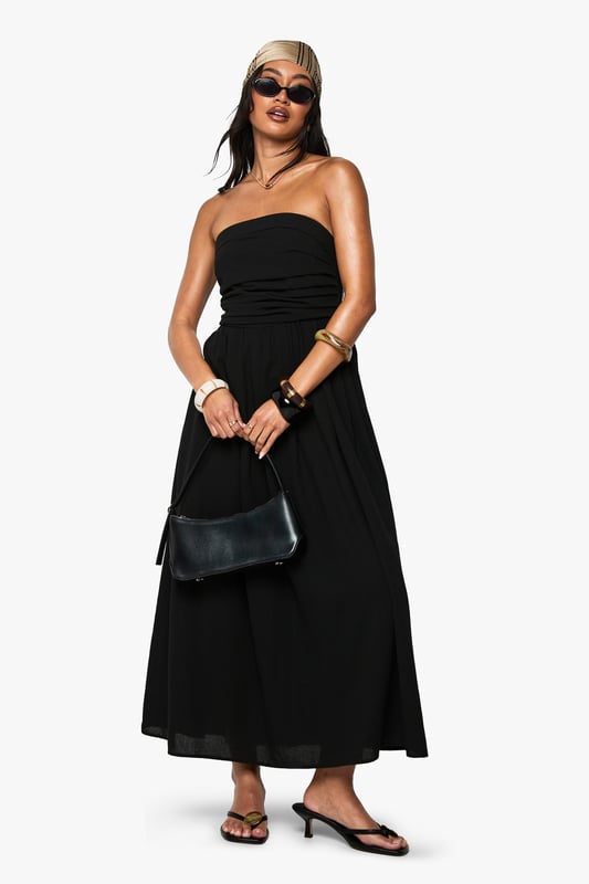 Chic bandeau neckline with a single shoulder strap for added support
        Flattering gathered waistband that defines your silhouette
        Flowing midi-length skirt with elegant side slit for ease of movement
        Lightweight linen-look fabric perfect for warm-weather occasions
        Versatile design that can be dressed up or down for various events
    
    This bandeau midi dress combines effortless style with practical comfort for your casual wardrobe. The striking asymmetric strap detail adds a contemporary twist to the classic bandeau design, while the gathered waistband creates a flattering shape that complements all figures. Style with flat sandals and a beanie for a relaxed daytime look, as shown by our model, or swap for kitten heels and statement jewellery for family gatherings. The side slit offers both practical movement and a subtle flash of leg, making this dress ideal for garden parties or brunches with friends. Layer with a denim jacket when the temperature drops or add a crossbody bag to keep your essentials close while maintaining the dress's clean lines. This Boohoo staple will quickly become your go-to for those "nothing to wear" moments.