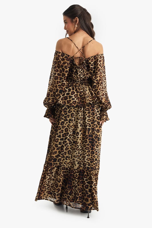 Off-shoulder design with adjustable spaghetti straps
        Voluminous balloon sleeves with ruffle details
        Tiered maxi silhouette for dramatic flair
        Alluring V-neckline enhances the dcolletage
        Chiffon fabric offers a lightweight, flowing feel
    
    Make a statement at your next formal event with this captivating chiffon maxi dress. The off-shoulder design, coupled with adjustable spaghetti straps, allows for a customised fit while showcasing your shoulders. The dress's tiered silhouette creates a cascading effect, perfect for twirling on the dance floor at weddings or garden parties. Style it with strappy metallic heels and statement earrings for a sophisticated look. For cooler evenings, drape a sleek pashmina over your shoulders. This versatile piece transitions seamlessly from daytime events to evening soires, making it a must-have addition to your occasion wear wardrobe. Whether you're attending a summer wedding or a glamorous cocktail party, this dress promises to turn heads and keep you feeling confident and stylish throughout the event.