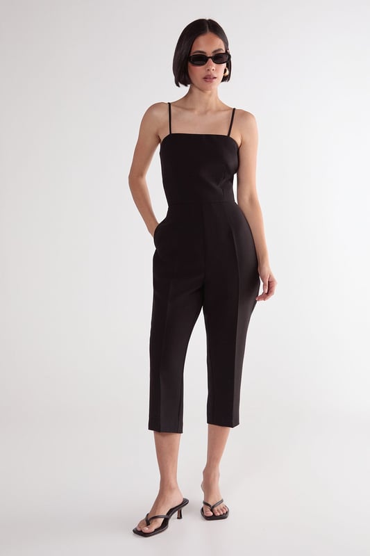 Sleek capri-length playsuit with tailored fit for a flattering silhouette
        Elegant square neckline with delicate adjustable spaghetti straps
        Practical side pockets for convenient storage of small essentials
        Cropped leg design offers a modern, sophisticated twist on classic playsuit styling
        Structured woven fabric provides comfortable stretch while maintaining shape
    
    This versatile Nasty Gal playsuit combines timeless tailoring with contemporary design for effortless style. The structured capri-length creates a refined silhouette that works beautifully for casual daytime events. Style with strappy kitten heels and statement earrings as seen on our model for family gatherings, or dress down with trendy trainers and an oversized tote for weekend brunches. The clean lines and minimalist design make this piece particularly adaptable for transitional weather-simply layer with a lightweight cardigan or cropped jacket when temperatures drop. The tailored fit flatters the waistline while the practical pockets add functionality to this chic wardrobe staple. Perfect for those seeking a balance of comfort and style for various casual occasions.