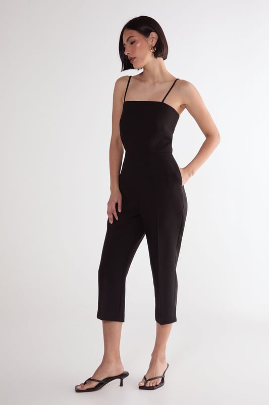 Sleek capri-length playsuit with tailored fit for a flattering silhouette
        Elegant square neckline with delicate adjustable spaghetti straps
        Practical side pockets for convenient storage of small essentials
        Cropped leg design offers a modern, sophisticated twist on classic playsuit styling
        Structured woven fabric provides comfortable stretch while maintaining shape
    
    This versatile Nasty Gal playsuit combines timeless tailoring with contemporary design for effortless style. The structured capri-length creates a refined silhouette that works beautifully for casual daytime events. Style with strappy kitten heels and statement earrings as seen on our model for family gatherings, or dress down with trendy trainers and an oversized tote for weekend brunches. The clean lines and minimalist design make this piece particularly adaptable for transitional weather-simply layer with a lightweight cardigan or cropped jacket when temperatures drop. The tailored fit flatters the waistline while the practical pockets add functionality to this chic wardrobe staple. Perfect for those seeking a balance of comfort and style for various casual occasions.