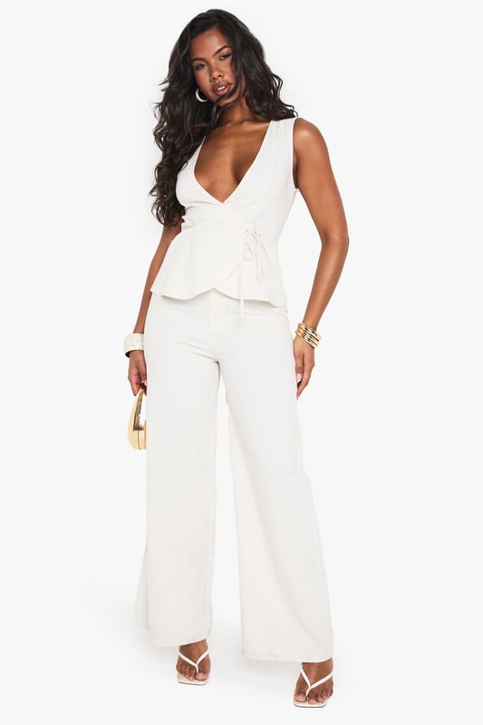 Striking linen-look jumpsuit with a daring plunge neckline for a bold statement
        Flattering peplum detail at the waist creates a feminine silhouette
        Wide-leg trousers offer comfortable movement and on-trend styling
        Sleeveless design perfect for showcasing jewellery and summer-ready arms
        Versatile piece that transitions effortlessly from day to evening occasions
    
    Make an entrance in this showstopping linen-look jumpsuit from Boohoo. The dramatic plunge neckline commands attention whilst the peplum waist detail adds a touch of feminine flair to your silhouette. The flowing wide-leg cut creates a statuesque effect that's both comfortable and fashion-forward. Style with strappy heels and stacked bangles as seen on our model for a night out with the girls, or dress down with flat sandals for daytime drinks. This jumpsuit works brilliantly for summer soires, cocktail parties, or any occasion where you want to stand out from the crowd. Layer with a tailored blazer when the temperature drops for a look that maintains its sophistication whilst adding practicality.