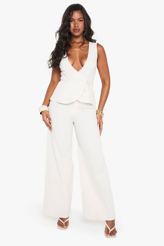 Striking linen-look jumpsuit with a daring plunge neckline for a bold statement
        Flattering peplum detail at the waist creates a feminine silhouette
        Wide-leg trousers offer comfortable movement and on-trend styling
        Sleeveless design perfect for showcasing jewellery and summer-ready arms
        Versatile piece that transitions effortlessly from day to evening occasions
    
    Make an entrance in this showstopping linen-look jumpsuit from Boohoo. The dramatic plunge neckline commands attention whilst the peplum waist detail adds a touch of feminine flair to your silhouette. The flowing wide-leg cut creates a statuesque effect that's both comfortable and fashion-forward. Style with strappy heels and stacked bangles as seen on our model for a night out with the girls, or dress down with flat sandals for daytime drinks. This jumpsuit works brilliantly for summer soires, cocktail parties, or any occasion where you want to stand out from the crowd. Layer with a tailored blazer when the temperature drops for a look that maintains its sophistication whilst adding practicality.