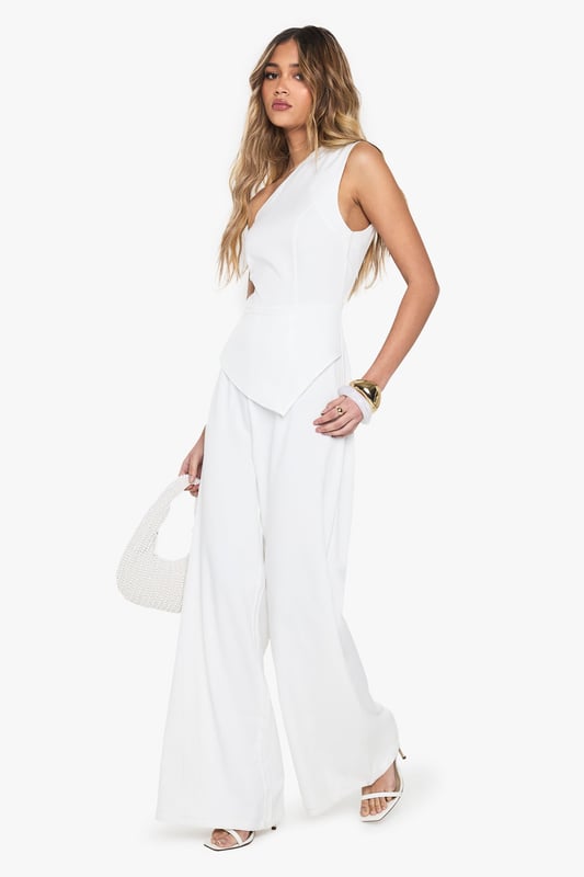 One-shoulder asymmetric neckline for a bold statement
        Wide-leg silhouette offering comfort and style
        Sleek crepe fabric for a polished look
        Single sleeve design adding a unique twist
        Floor-length cut for an elongating effect
    
    Make a striking entrance in this one-armed wide-leg jumpsuit from Boohoo. The asymmetric neckline and single sleeve design create a captivating silhouette that's sure to turn heads. Perfect for casual events or family gatherings, this versatile piece can be dressed up or down with ease. Pair with flat sandals and minimal jewellery for a relaxed daytime look, or add statement earrings and a clutch bag for evening drinks. The wide-leg cut offers both comfort and style, while the crepe fabric ensures a smooth, flattering fit. Ideal for the fashion-forward woman who wants to stand out without compromising on comfort, this jumpsuit is a must-have addition to your wardrobe. Its clean lines and modern design make it a go-to choice for those impromptu plans or when you want to feel effortlessly chic.