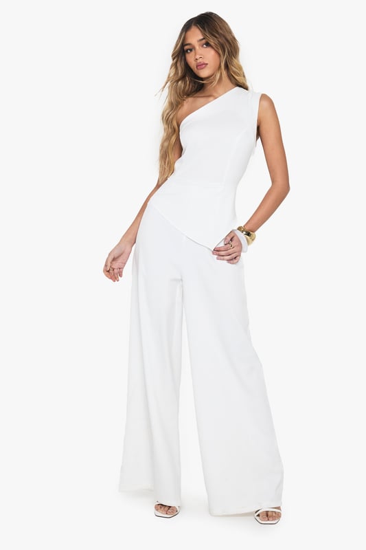 One-shoulder asymmetric neckline for a bold statement
        Wide-leg silhouette offering comfort and style
        Sleek crepe fabric for a polished look
        Single sleeve design adding a unique twist
        Floor-length cut for an elongating effect
    
    Make a striking entrance in this one-armed wide-leg jumpsuit from Boohoo. The asymmetric neckline and single sleeve design create a captivating silhouette that's sure to turn heads. Perfect for casual events or family gatherings, this versatile piece can be dressed up or down with ease. Pair with flat sandals and minimal jewellery for a relaxed daytime look, or add statement earrings and a clutch bag for evening drinks. The wide-leg cut offers both comfort and style, while the crepe fabric ensures a smooth, flattering fit. Ideal for the fashion-forward woman who wants to stand out without compromising on comfort, this jumpsuit is a must-have addition to your wardrobe. Its clean lines and modern design make it a go-to choice for those impromptu plans or when you want to feel effortlessly chic.